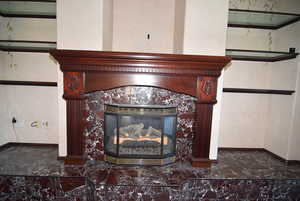Detailed view of a tile fireplace and baseboards