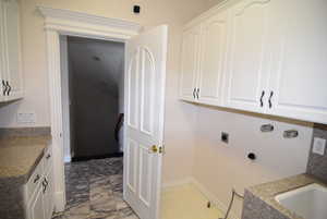 Laundry area with hookup for an electric dryer and cabinet space