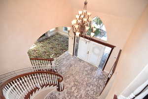Entrance foyer featuring a towering ceiling, a chandelier, and arched walkways