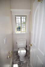 Bathroom featuring toilet and baseboards