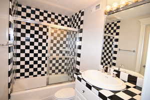 Bathroom with enclosed tub / shower combo and vanity