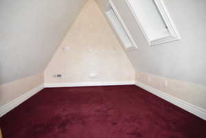 Bonus room with a skylight, lofted ceiling, and carpet flooring