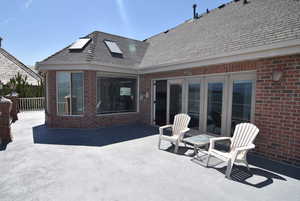 Rear view of property featuring brick siding and a patio