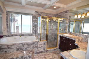Full bath with a shower stall, vanity, light marble finish floors, a garden tub, and beam ceiling