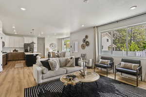 Living room with light wood-style flooring and recessed lighting