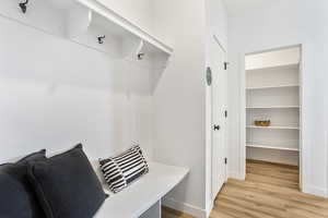 Mudroom with light wood-style floors and baseboards