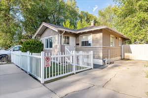 View of front of home with a fenced front yard and a chimney