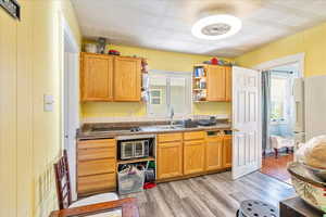 Kitchen featuring dark countertops, plenty of natural light, and light wood-style flooring
