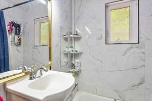 Bathroom featuring vanity and shower / tub combo with curtain