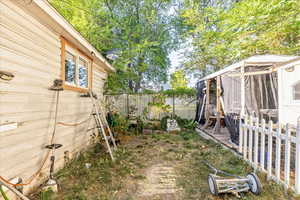 View of yard featuring an outdoor structure and a sunroom