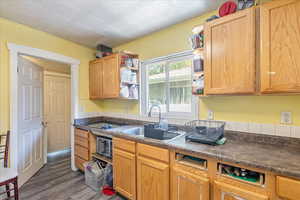 Kitchen with dark countertops, dark wood finished floors, open shelves, an ornate ceiling, and brown cabinetry