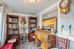 Home office with wood finished floors and ornamental molding