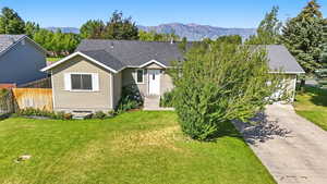 View of front of house featuring a shingled roof, a mountain view, and driveway