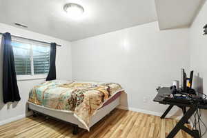 Bedroom featuring light wood-style floors and a textured ceiling