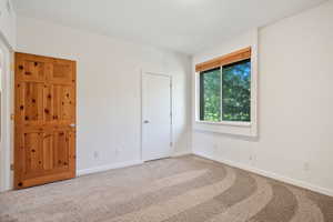Unfurnished bedroom featuring carpet floors and baseboards