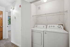 Washroom featuring carpet floors and washer and clothes dryer