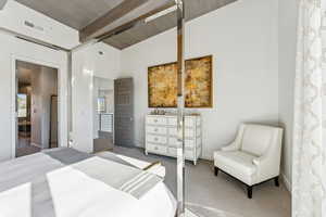 Carpeted bedroom with beam ceiling and baseboards