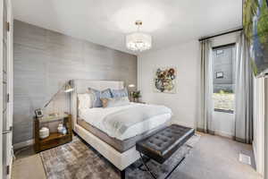 Bedroom featuring light carpet and an accent wall