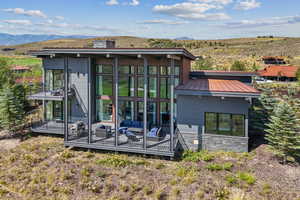 Back of house featuring a metal roof, stone siding, a standing seam roof, and a mountain view