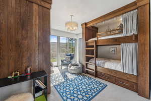 Carpeted bedroom with access to outside and a chandelier