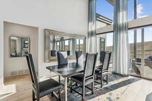 Dining area featuring wood finish floors and a towering ceiling