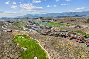 Drone / aerial view of a water and mountain view and a local golf course