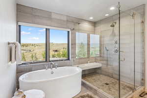 Bathroom with a soaking tub, tile walls, a shower stall, and recessed lighting