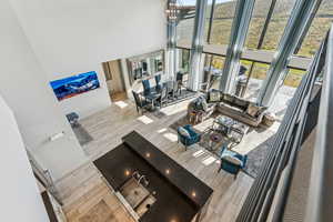 Living area featuring wood finish floors, a towering ceiling, and a chandelier