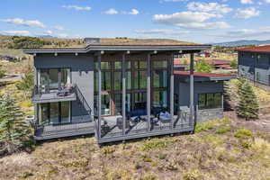 Rear view of house with a sunroom and a mountain view