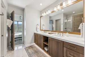 Full bathroom featuring double vanity, ensuite bath, a stall shower, and recessed lighting