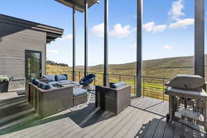 Wooden terrace with a grill and outdoor lounge area