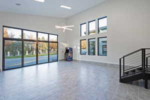 Empty room featuring plenty of natural light, a towering ceiling, and a chandelier