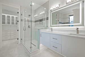 Full bath with double vanity and a stall shower
