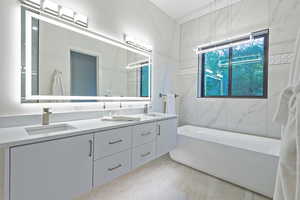 Bathroom featuring a soaking tub and double vanity