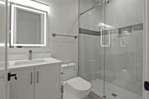 Full bath with a shower stall and vanity