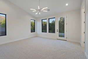 Unfurnished room featuring vaulted ceiling, a chandelier, light colored carpet, and recessed lighting