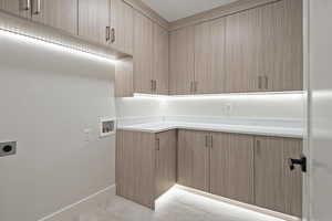 Laundry area featuring cabinet space, washer hookup, and electric dryer hookup