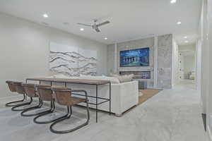 Living room with recessed lighting, ceiling fan, and a tiled fireplace