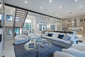Living area with recessed lighting, stairs, and a towering ceiling