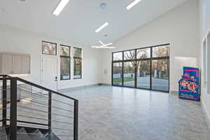 Unfurnished living room with high vaulted ceiling and a chandelier