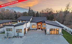 Front of house with stone siding, decorative driveway, a garage, and a mountain view