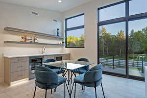 Dining space featuring beverage cooler and recessed lighting