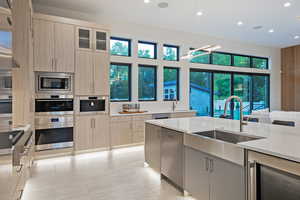 Kitchen with wine cooler, light stone countertops, light brown cabinets, recessed lighting, and modern cabinets