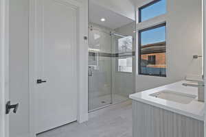 Bathroom featuring a stall shower and double vanity