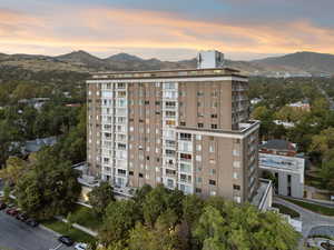 Property at dusk with a mountain view and a view of apartment building / complex