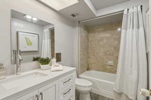 Full bath featuring shower / tub combo with curtain, vanity, and dark wood-style floors