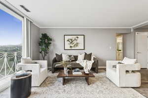 Living area with wood finished floors, expansive windows, and crown molding