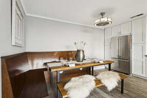 Dining area with crown molding and wood finished floors