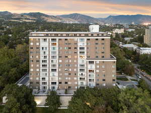 Property at dusk with a mountain view and a view of apartment building / complex