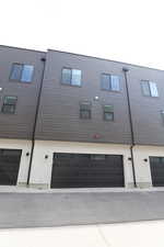 Rear view of house with a garage and stucco siding